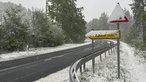 Zwei Straßenschilder an einer Straße von Schnee bedeckt