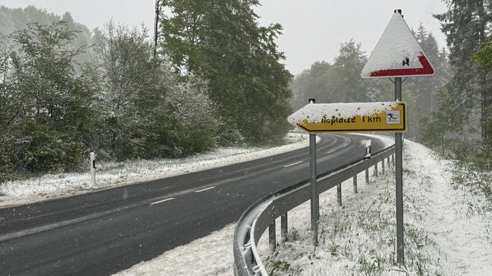 Zwei Straßenschilder an einer Straße von Schnee bedeckt