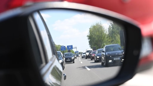 Ein Stau im Rückspiegel eines Autos auf der Autobahn