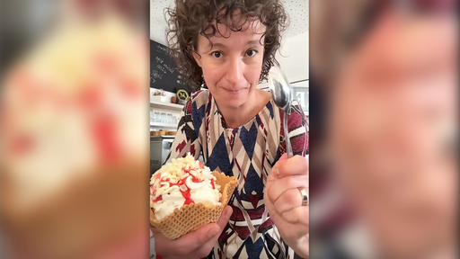 Screenshot eines TikTok Videos. Man sieht eine Frau mit braunen Locken. Sie hält ein Spaghetti-Eis in die Kamera. 