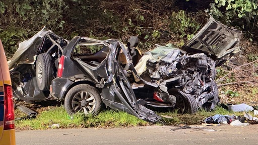 Ein demoliertes Auto liegt am Straßenrand