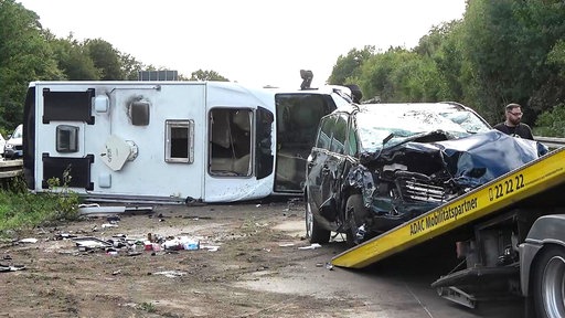Der Pkw steht vor einer Abschlepprampe, während das Wohnmobil noch immer seitlich auf der Straße liegt.