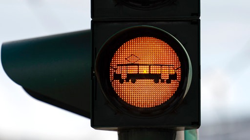 Eine Ampel warnt Fußgänger vor der Straßenbahn.