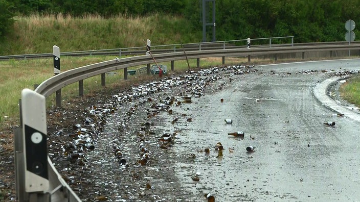Autobahnausfahrt, mehrere kaputte Glasflaschen liegen auf der Fahrbahn