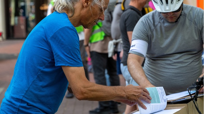 Ein MItglied der Initiative Radentscheid Essen sammelt am Rande der Demonstration des Radentscheids in Essen Unterschriften für das Bürgerbegehren.