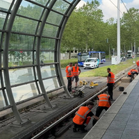 Personen in orangenen Warnwesten stehen auf dem Gleis.