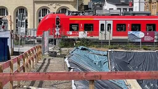 Eine rote S-Bahn fährt an einer Baustelle vorbei