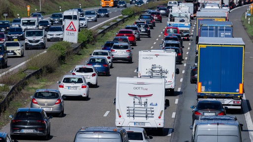 Stau auf einer Autobahn mit Pkw, Lkw und Wohnmobilen