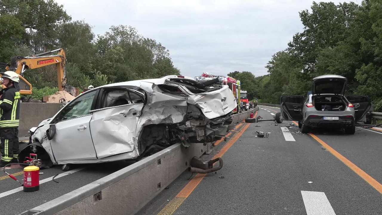 Das Bild zeigt mehrere beschädigte Pkw und Einsatzkräfte auf der A40.