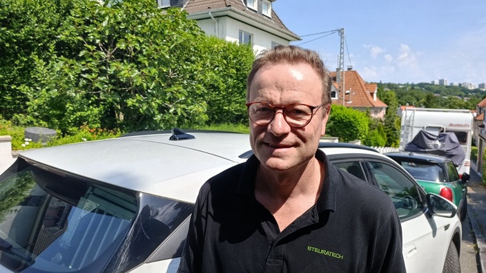 Mann steht vor einem Auto