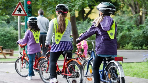 Kinder üben auf einem Verkehrsübungsplatz das richtige Verhalten mit dem Fahrrad im Straßenverkehr