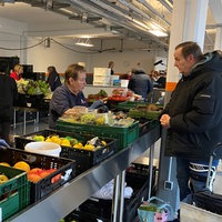 Essensausgabe und Kisten mit Gemüse in der Tafel Essen