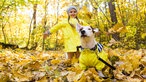 Mädchen mit Hund im Herbstlaub