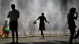 In Köln liegt ein Wasserschlauch mit Düsen, aus denen ein feiner Nebel gesprüht wird