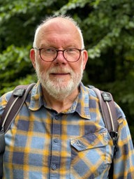Ein Mann mit weißen Haaren und Bart.