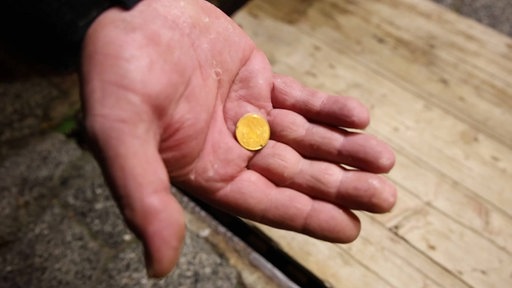 Eine Hand hält eine Zehn-Cent-Münze