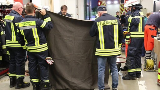 Feuerwehrleute im Einsatz, um das Mädchen aus dem Gullydeckel zu befreien