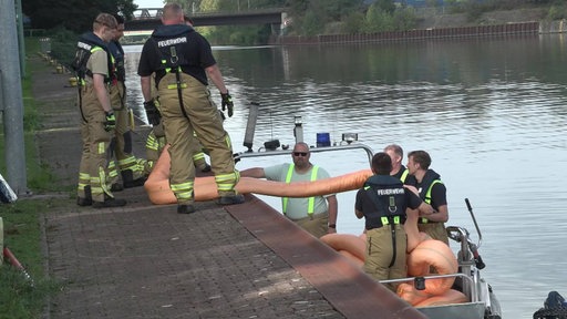 Feuerwehrkräfte kümemrn sich um den Ölfilm auf dem Rhein-Herne-Kanal