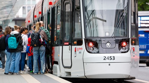 Kinder und Jugendiche steigen in eine Tram 