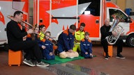 Fred Deitz und Hans Nickel begleiten einen Rettungssanitäter bei der Herzdruckmassage