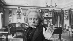 Collage: Edvard Grieg in einem Wohnzimmer