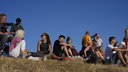 Einige Menschen sitzen zusammen auf einer Wiese und warten auf die Sonnenfinsternis