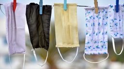 Stoffmasken hängen auf Wäscheleine zum Trocknen