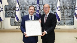André Kuper, Präsident des Landtags, überreicht ein Werk von Günter Uecker an Itzhak Herzog, Israels Staatspräsidenten