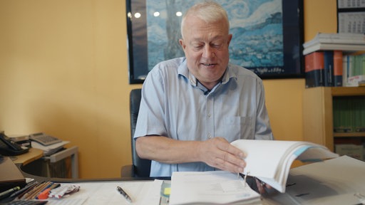 Der Anwalt Detelf Rückel durchsucht eine Akte