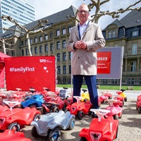 Jochen Ott, Vorsitzender der SPD Fraktion im Landtag von NRW, steht beim Auftakt der Dialogtour "Fraktion auf Achse" zwischen Bobby-Cars vor der Staatskanzlei