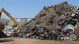 Die Recyclinganlage IMR in Krefeld: Ein großer Berg aus Material, danaben zwei Bagger.