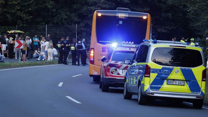 Ein Bus steht an der Seite. Drum herum findet ein Polizeieinsatz statt