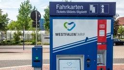 Ein blauer Fahrkartenautomat mit der Aufschrift "Westfalentarif" steht an einem Busbahnhof.