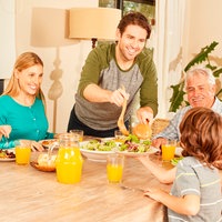 Erweiterte Familie mit Großeltern und Kindern beim Mittagessen am Esstisch