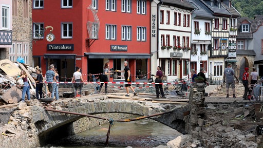 Menschen räumen auf im zerstörten Zentrum von Bad Münstereifel nach der Flutkatastrophe im Jahr 2021.