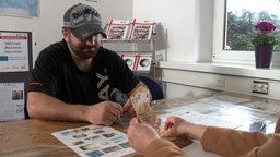 Freiwillige Ausreise wird in einem Beratungstermin vorbereitet, Geld wird gezählt.