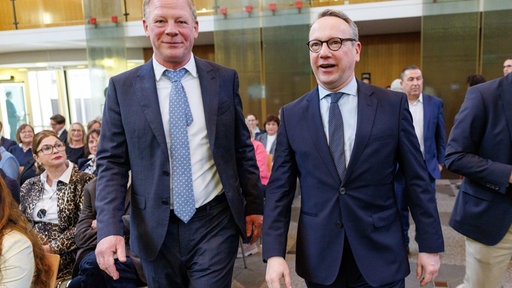 Carsten Günther (l) geht bei seiner Amtseinführung zum Präsident am Oberverwaltungsgericht (OVG) für das Land Nordrhein-Westfalen neben NRW-Justizminister Benjamin Limbach (Grüne). 