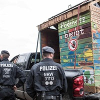 07.10.2018, Nordrhein-Westfalen, Kerpen: Einsatzkräfte der Polizei stehen neben einem auf einen Wagen geladenen Bretterhaus aus dem Hambacher Forst. Das Haus kommt nun ins Museum. Das Bonner Haus der Geschichte baut seine Dauerausstellung um.