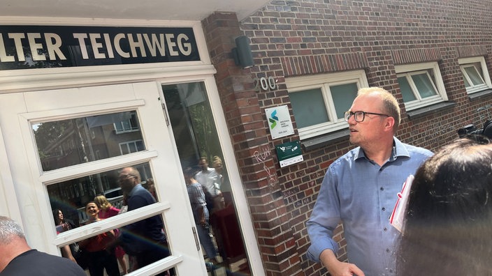 Jochen Ott (SPD) steht vor einer Hamburger Statdteilschule