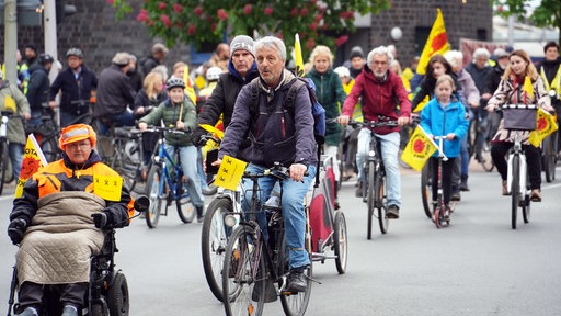 Demonstranten auf Fahrrädern mit Atomkraft-Nein-Danke-Flaggen.