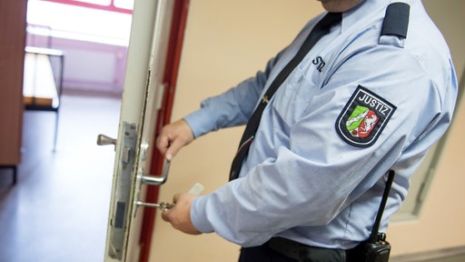 Ein Justizvollzugsbeamter schließt in der JVA Gelsenkirchen eine Tür