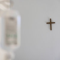  Ein Krankenzimmer im Katholischen Krankenhaus KKH in Erfurt. Ein Kreuz hängt an der weißen Wand und im Vordergrund verschwommen Krankenhaus Einrichtung.