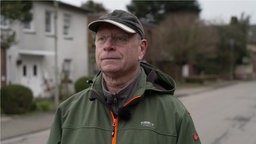 Oliver Kanneberg im Interview. Er steht auf einer leeren Straße.