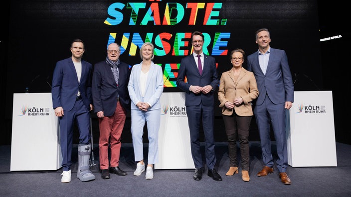 Markus Rehm, paralympischer Sportler, Peer Steinbrück, ehem. NRW-Ministerpräsident, Britta Heidemann, ehemalige Fechterin, Ministerpräsident Hendrik Wüst (CDU), Isabell Werth, Dressurreiterin, und Sebastian Schulte bei einer Pressekonferenz zu Olympia.