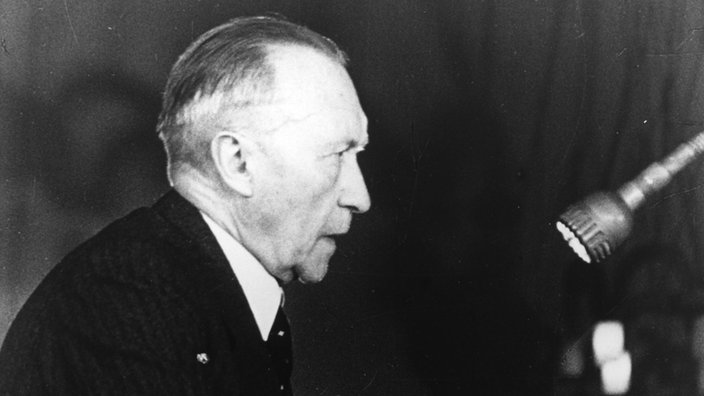 Porträtfoto Konrad Adenauer aus dem Jahr 1948 zeigt ihn im Profil an einem Rednerpult stehend
