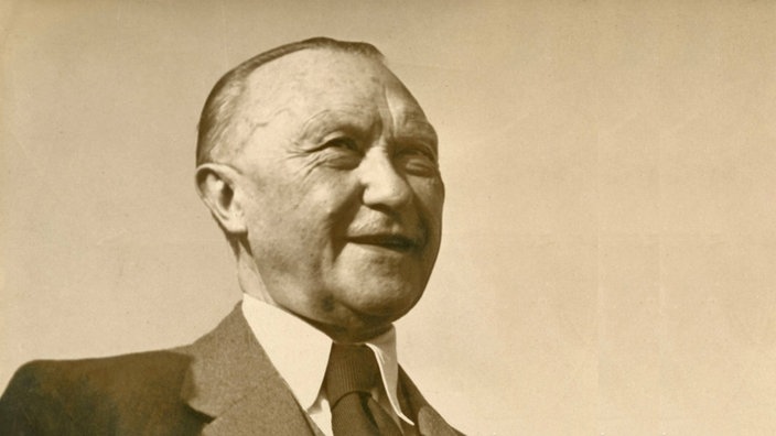Porträtfoto Konrad Adenauer aus dem Jahr 1950, er schaut frohgemut lächelnd zur Seite