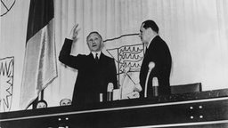Konrad Adenauer (links) wird 1949 von Bundestagspräsident Erich Köhler vereidigt, Adenauer hebt die rechte Hand zum Amtseid