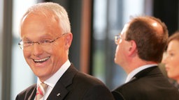 Jürgen Rüttgers (CDU) am Wahlabend 2005 lächelnd, im Hintergrund steht der unterlegene Ministerpräsident Peer Steinbrück (SPD)