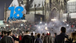 Menschmenge steht bei Nacht vor Kölner Dom 