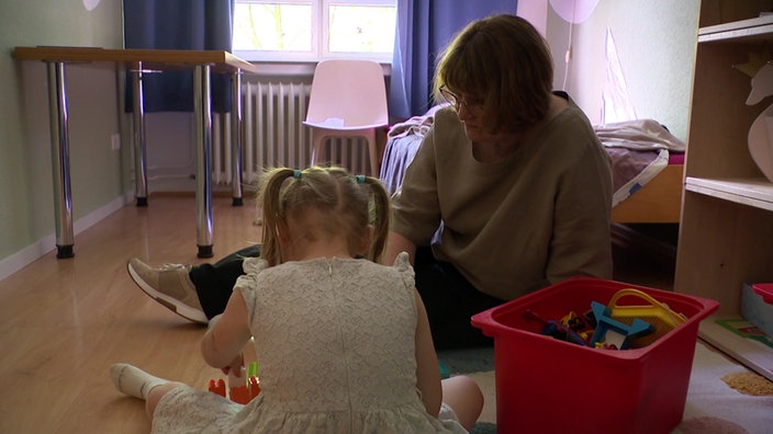 Pädagogin und Kind spielen zusammen